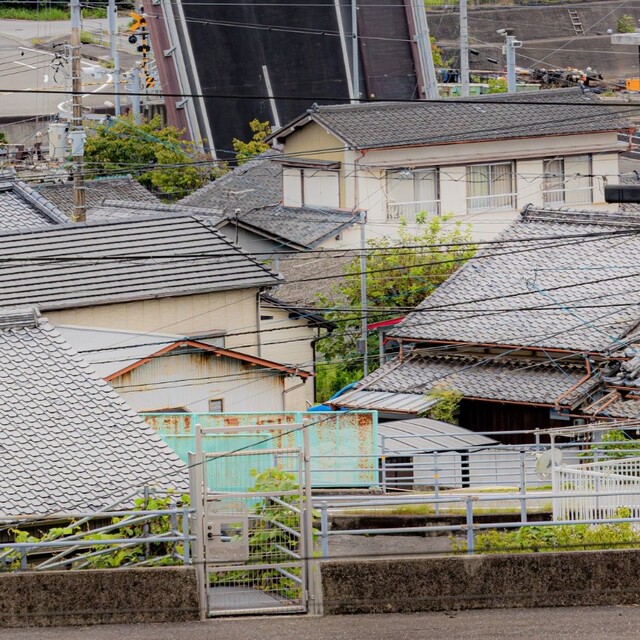 The road fell from the sky...!? A giant piece of asphalt piercing a house has left people astonished, asking, 'What's going on?'.